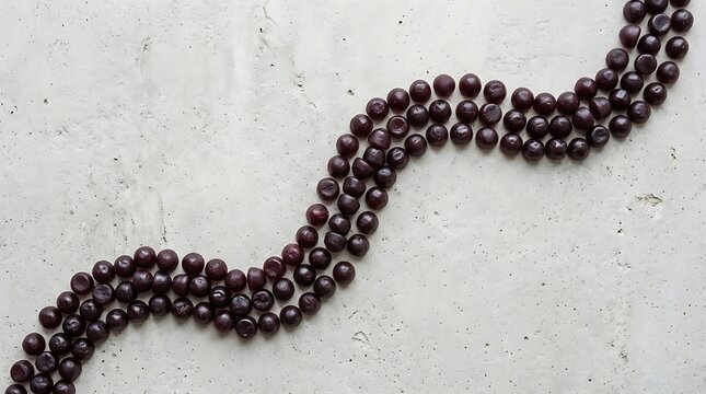 Dark purple elderberry gummy vitamins arranged in a professional S-shaped pattern on a neutral concrete surface for health and wellness supplement marketing.