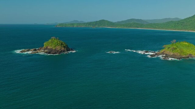 Aerial Orbit Around Islet Near Nacpan Beach in El Nido, Philippines. Cinematic Drone Curved Tracking View of Small Rocky Island Outcropping and Turquoise Ocean Water.
