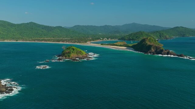 Aerial Forward Tracking Shot from Islet Towards Nacpan Beach in El Nido, Philippines. Drone View Flying Over Turquoise Ocean Water Toward Sweeping Golden Sand Shoreline and Hills.