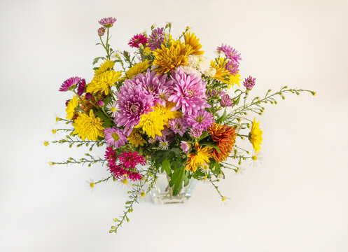 Vibrant autumn flowers bouquet in a glass vase.
