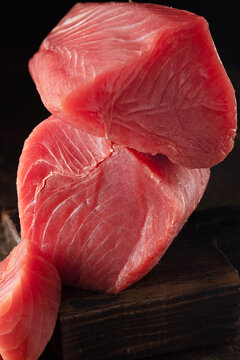 Fillet of fresh tuna fish for Japanese cuisine. Large piece of raw red tuna on wooden board. Natural omega. Large piece of raw fish steak for sushi and sashimi. Raw tuna steak
