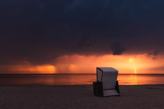 Strandkorb am Sandstrand der Ostsee bei Blitz und Gewitter
