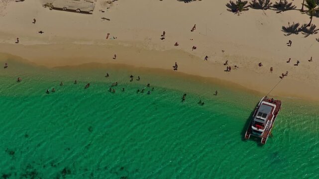 Aerial Zoomed In Backwards Shot of Seven Commandos Beach Shoreline in El Nido, Philippines. Drone Pull Away Over Shallow Turquoise Ocean Water and White Sand Beach.