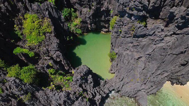 Aerial Ascent Shot From Secret Lagoon in El Nido, Philippines. Cinematic Drone Vertical Pedestal Up Over Turquoise Water Enclosed by Towering Limestone Cliffs.