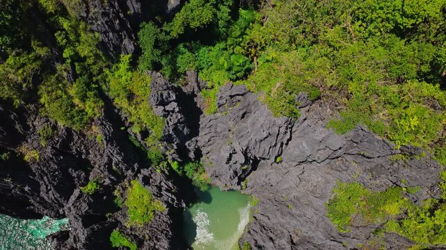 Aerial Backwards Reveal of Secret Lagoon in El Nido, Philippines. Cinematic Drone Pull Away Shot at Fixed High Angle Over Turquoise Water and Limestone Cliffs.