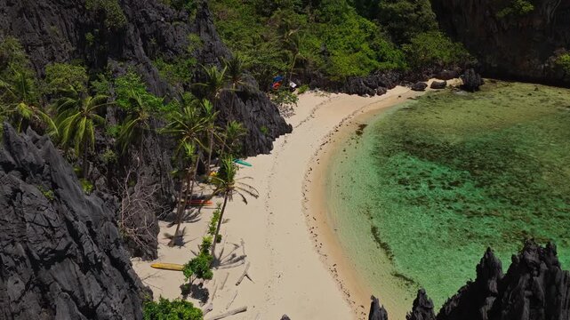 Aerial Forward Shot Along Isolated Beach Shoreline Near El Nido Secret Lagoon. Drone Flying Over Turquoise Ocean, Coral Reef, and Secluded White Sand in the Philippines.