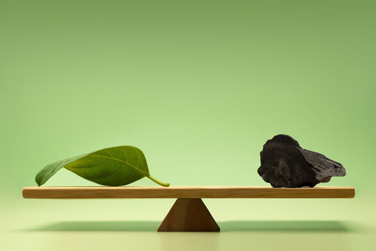 Balance scale with green leaf and coal, Carbon emission balance, environmental sustainability and climate change