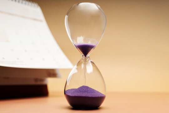 Hourglass beside calendar, time management, aging society and awareness