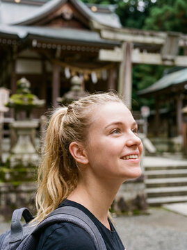 神社を観光する笑顔の外国人女性トラベラー