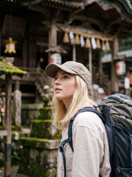 日本の伝統的な神社を訪れる外国人女性バックパッカー
