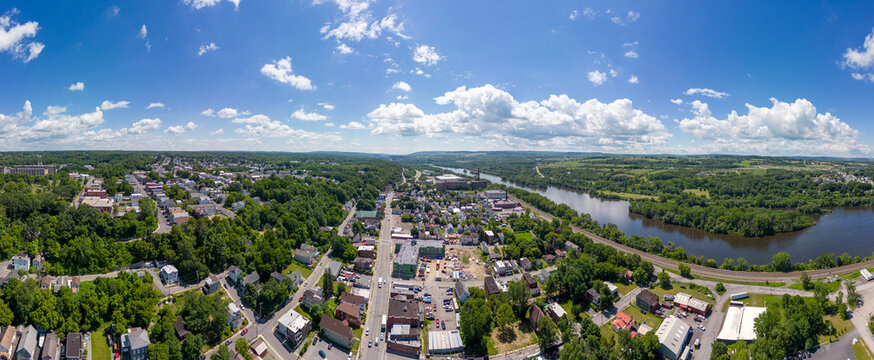 Panoramic aerial view of Amsterdam, New York, USA,  along the winding Mohawk River under blue skies.  July 6, 2022. 