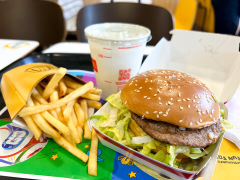 Close up view of a medium sized portion of McDonalds fries and a Big Mac hamburger in special World Cup packaging with banana milkshake for lunch