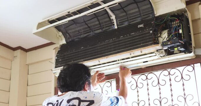 Mechanic man repair and clean air condition in city home diagnostic electronic industry