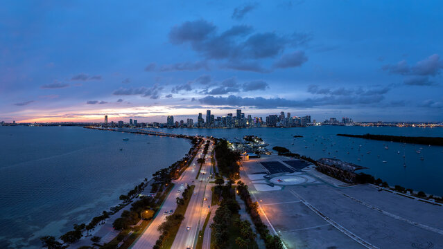 Panoramic aerial view of the Miami skyline at dusk with illuminated causeway stretching over Biscayne Bay, Florida, USA. January 3, 2024. 