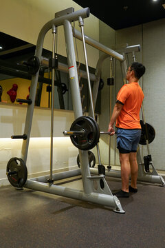 Man doing deadlift with rack machine in private gym