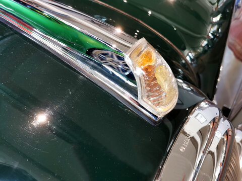 Detail Blinklicht eines Mercedes Benz 300 aus der Adenauerzeit Modell 186 und imChrom spiegelt sich ein moderner Mercedes SPortwagen
