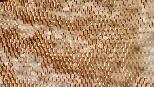Papel cart&atilde;o com pequenos furos sobre mesa de madeira e ilumina&ccedil;&atilde;o quente natural