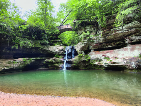 Small Waterfall and Stone Bridge in a Lush Green Gorge