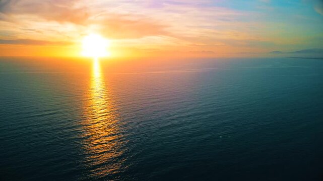A breathtaking panoramic view of a dramatic golden sunset over the Mediterranean Sea in Agropoli, Cilento coast. The sky is filled with vibrant hues of orange, pink, yellow, and blue clouds, while the