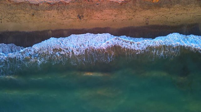 Aerial photography in 4K format &ndash; aerial view (ultra-high resolution) of sunset or sunrise on the seashore. Reflection in the water. Beautiful summer seascape of the Mediterranean Sea. Background 