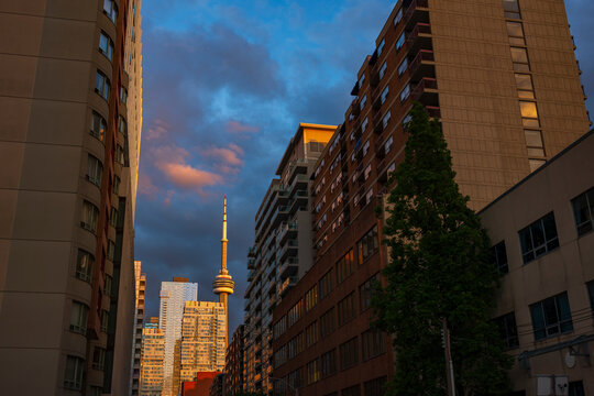 Cityscape of the Toronto skyline photographed during a sunset with illuminated clouds in the sky during a summer evening.