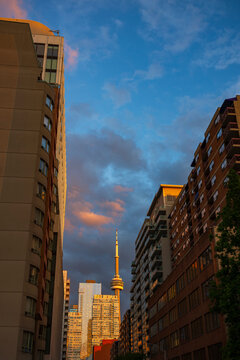 Cityscape of the Toronto skyline photographed during a sunset with illuminated clouds in the sky during a summer evening.