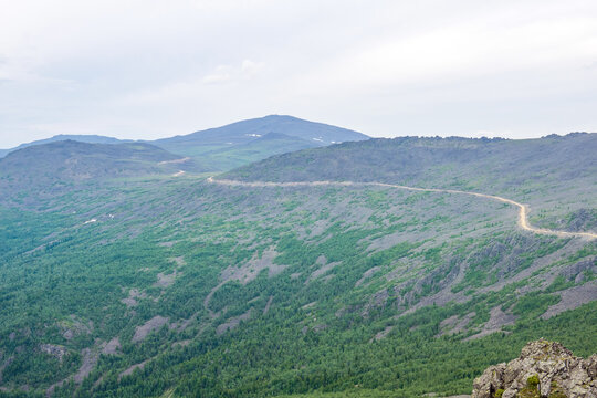 Mountain landscape in summer. Distant road through the mountains.