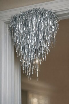 A chandelier hangs from the ceiling of a house, providing warm lighting
