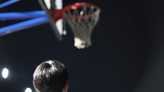 [Slow Motion] A basketball player making a shot&mdash;a video evoking the spirit of sports and practice as the player strives to score. A faceless figure seen from behind.