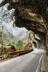Fototapeta premium Curving mountain road through rock tunnel