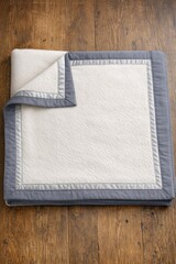 Fototapeta premium A simple white and grey blanket lying on a wooden floor
