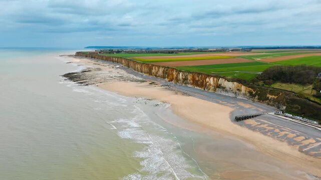 Rural fields meeting cliff edge above English Channel coast in Normandy, France. Drone view of coastal landscape and beach