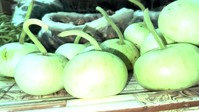 Bottle Gourd Bounty: A close-up view of a pile of fresh, green bottle gourds, their unique curved stems adding a touch of natural artistry to the rustic display.
