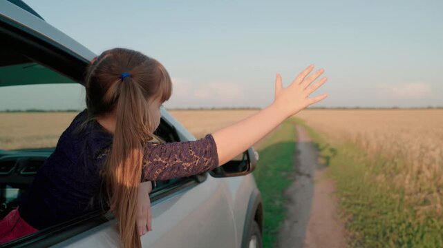 little girl child kid waving hand through car window, road trip girl, traveling by car with windows open, freedom summer car ride, happy family, child girl feeling breeze hair, child hair fluttering