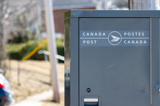 Quebec, Canada, 26 April 2026 : A grey Canada Post mail collection box stands on a street in a residential area.