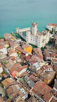 Aerial view of Sirmione old town with Scaliger Castle on Lake Garda. Tiled roofs, streets and historic urban layout in Italy