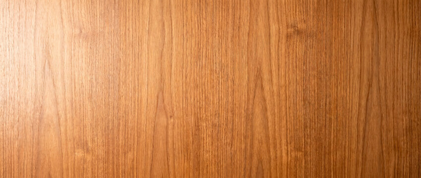 Warm teak wood veneer texture background with natural straight grain pattern