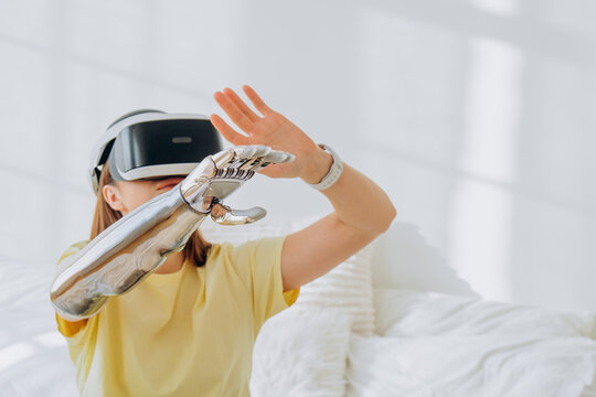 Woman wearing a virtual reality headset and bionic prosthetic arm, reaching out to interact with an immersive digital interface, exploring futuristic technology and human computer interaction