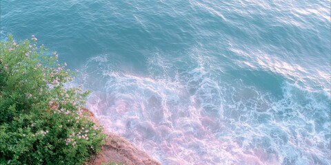 Fototapeta premium ocean waves, cliff edge with green vegetation, light blue and pink tones