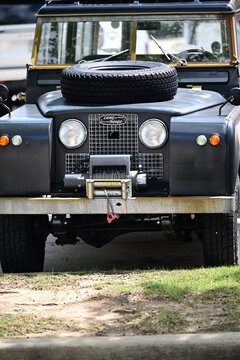 iconic vintage Land Rover with aftermarket winch and spare tire on hood