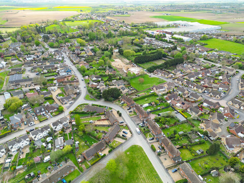 Drone view of a typical village which has expanded in the last 20 years. A small building plot near the centre of the image is for detached bungalows. Seen in rural Cambridgeshire, UK.
