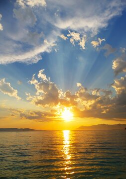 Divine sunset above the sea with dramatic clouds and rays of light seascape sunset background