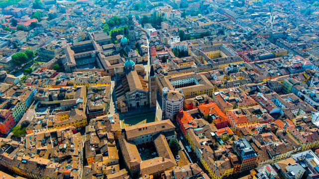 Aerial drone view of Parma Duomo Cathedral facade and Battistero Baptistery with Gothic bell tower above Piazza del Duomo and historic streetscape, Emilia-Romagna, Italy