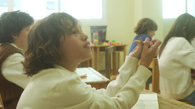 Multi-ethnic elementary school children assembling DIY robotic models during a STEM class with a senior teacher.