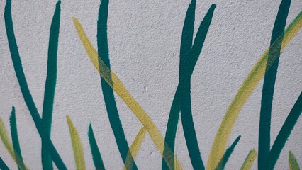 Hand painted green grass blades on white concrete wall mural detail © MDJAHIDHASAN