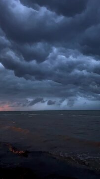 Dusk over turbulent sea with orange hues. Majestic dusk sky and crashing waves