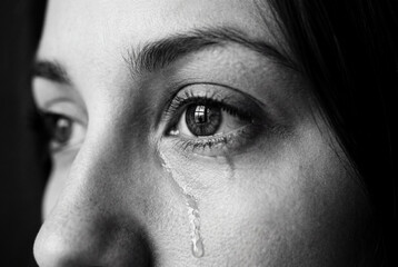 Naklejka premium Woman crying tear from eye in black and white