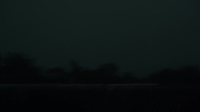 Windstorm with rain in rural countryside location during evening.