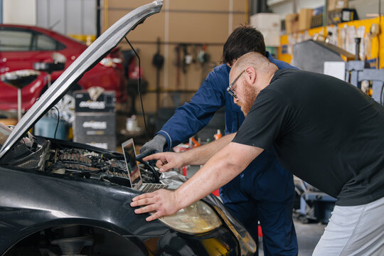 Car engineer technician worker, Technician team use laptop computer for tuning ECU with software.