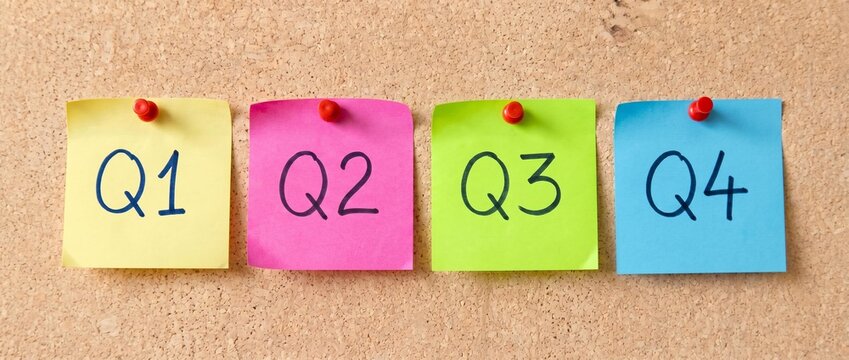 Four Colorful Sticky Notes Labeled Q1 to Q4 Pinned on a Corkboard, For Business Planning and Quarterly Financial Reporting